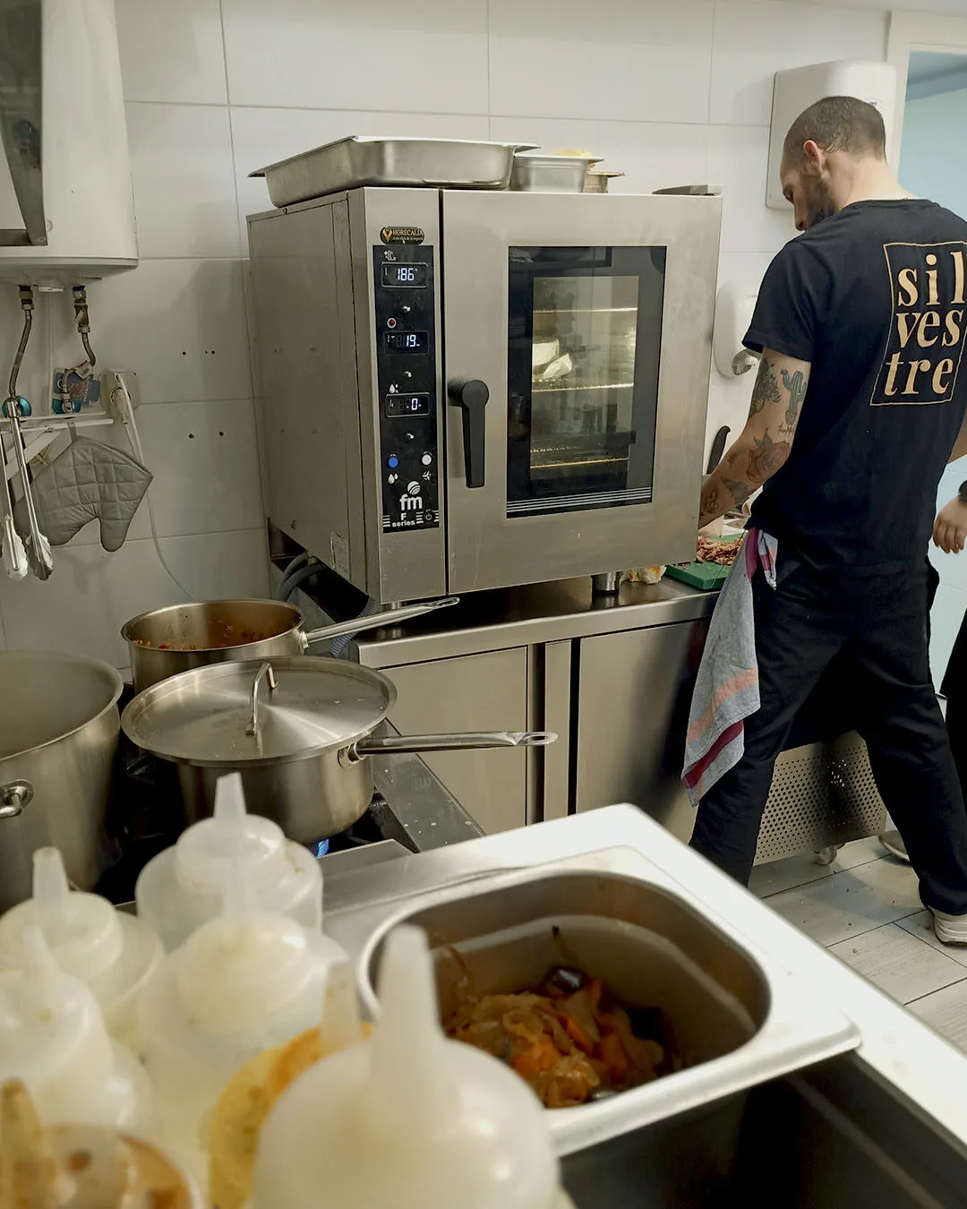 Cocina de Silvestre Becerril en pleno servicio junto al horno.
