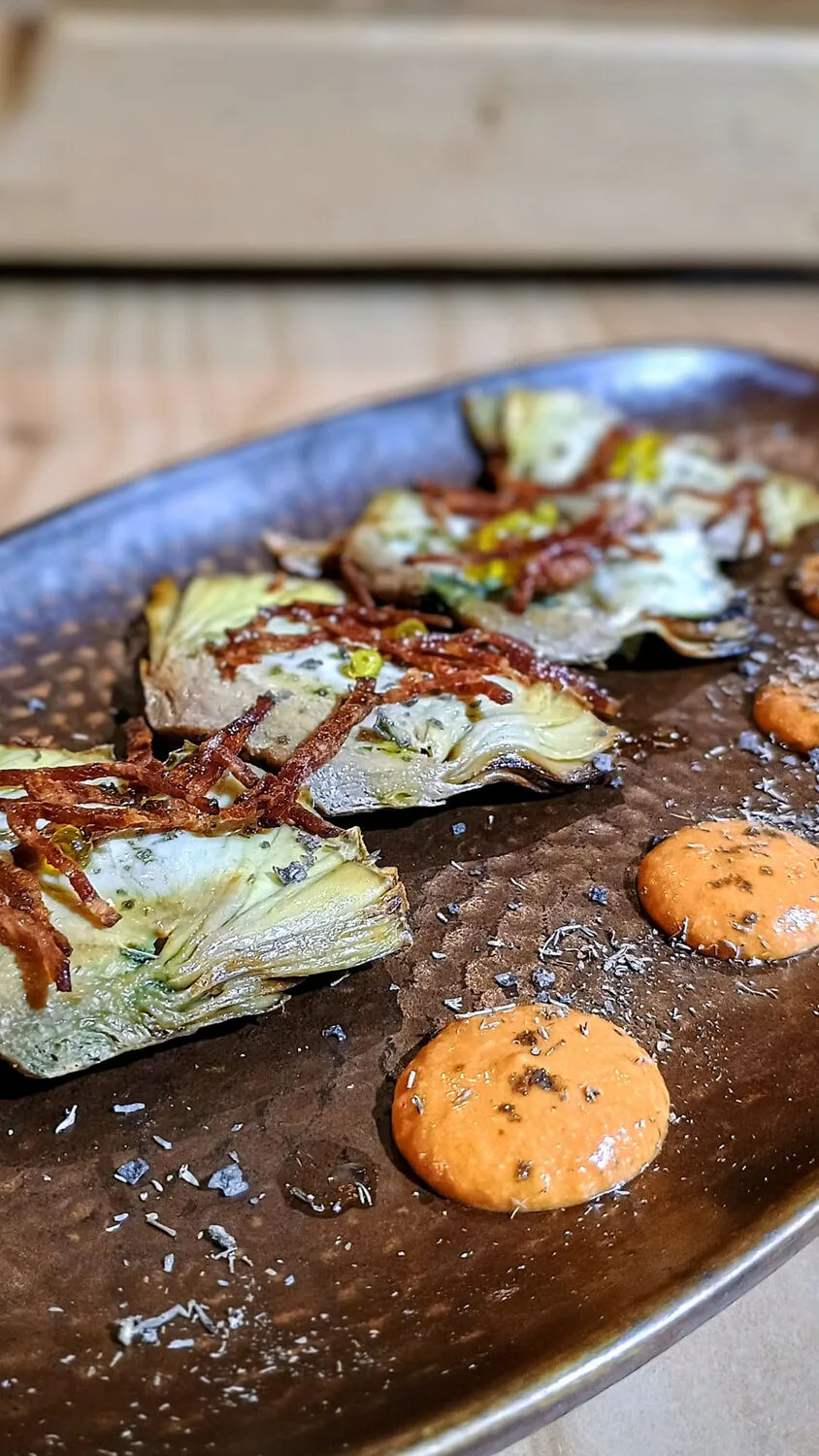 Alcachofas confitadas con salsa romesco, plato de Silvestre Mercado.