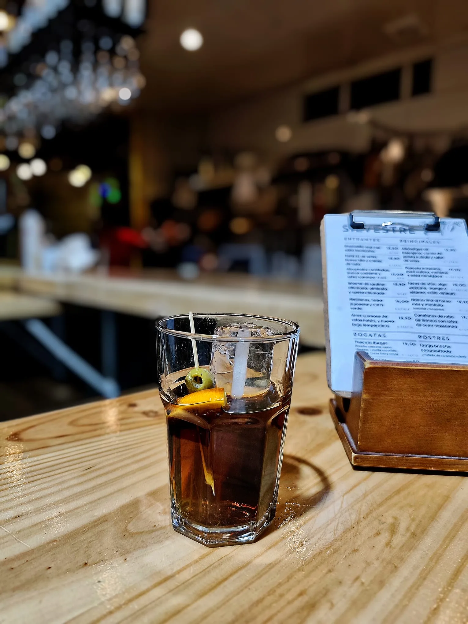 Vermut servido en copa con su rodaja de naranja en la barra de Silvestre.