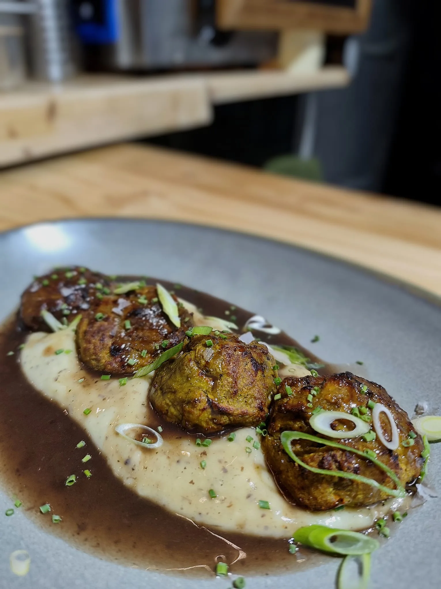 Albóndigas de berenjena con crema de patata trufada y salsa de setas.