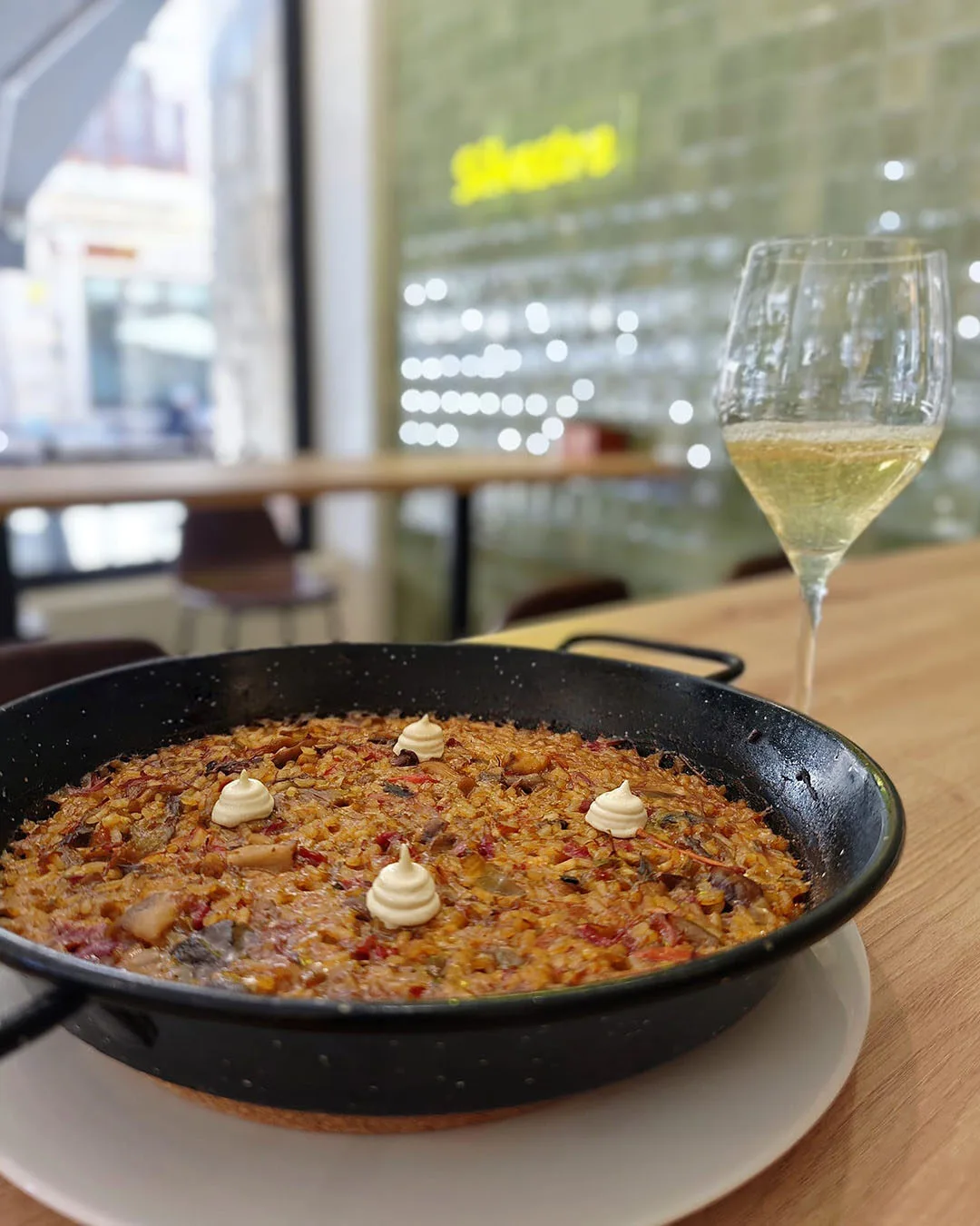 Arroz meloso de Silvestre Becerril servido con una copa de vino.